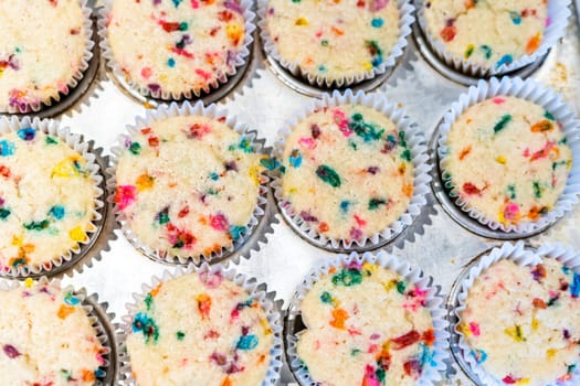 Funfetti cupcakes are cooling in a cupcake pan.