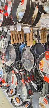 Bobruisk, Belarus - May 1, 2024: A collection of pans of different sizes and materials showcased on shelves for purchase in a store.