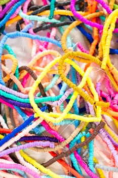 A vibrant collection of clay beads, neatly arranged by color on a white table, ready to inspire young crafters to create their own unique bracelets.