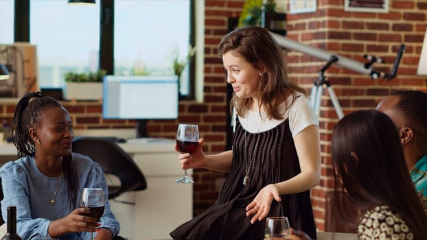 Woman talking with BIPOC apartment party guests during weekend gathering, rolling her eyes while gossiping about annoying friend. Multiethnic group of people listening to frustrated host venting