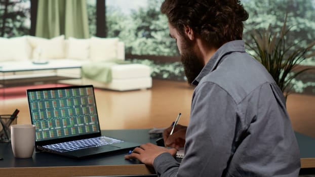 Financial advisor opening laptop to check revenue updates, banking specialist following international trends from his deluxe modern villa in the mountains. Self employed man at his vacation home.