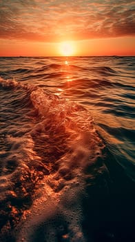 The sun is setting over the ocean, casting a warm glow on the water. The waves are small and gentle, creating a peaceful atmosphere