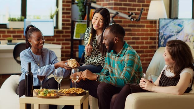 Multiracial friends throwing surprise birthday party forafrican american man, giving him thoughtful gift in living room. Smiling group of people celebrating host anniversary, gifting nice present