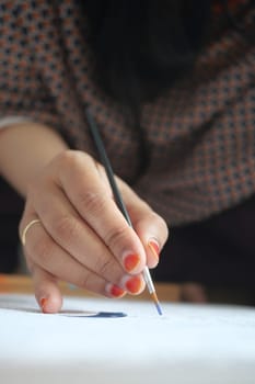 women hand holding brush with paint .