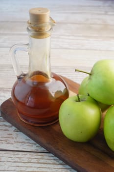 apple vinegar in glass bottle with fresh green apple on table ,