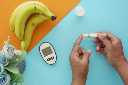 young man's hand measure glucose level at home.