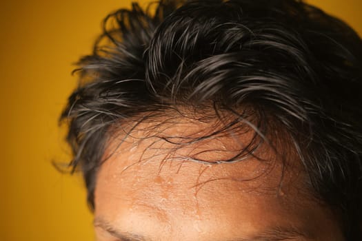 closeup of sweat on forehead against dark background