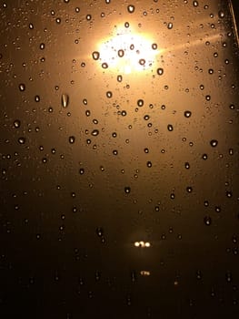 Rain Drops on Glass Window at Night by Streetlight. High quality photo