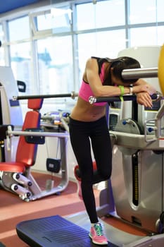 At gym. Tired after workout woman lies on simulator