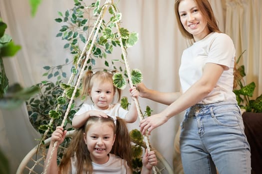 Happy family young mother babysitter relax having fun with cute little children daughters in living room at home