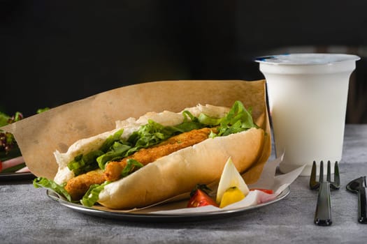 Fried fish sandwich with greens on the stone table. Turkish name Balik Ekmek