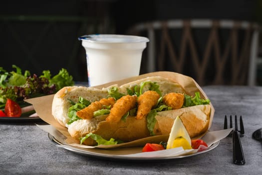 Deep fried shrimp in bread with greens on the side. Shrimp sandwich