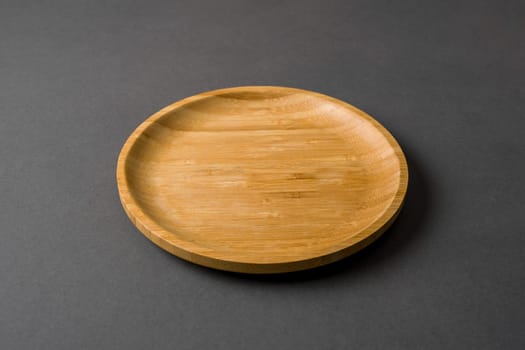 Wooden plate on dark gray background. handmade kitchen utensils