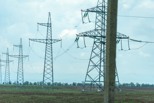 High voltage towers with sky background. Power line support with wires for electricity transmission. High voltage grid tower with wire cable at distribution station. Energy industry, energy saving.