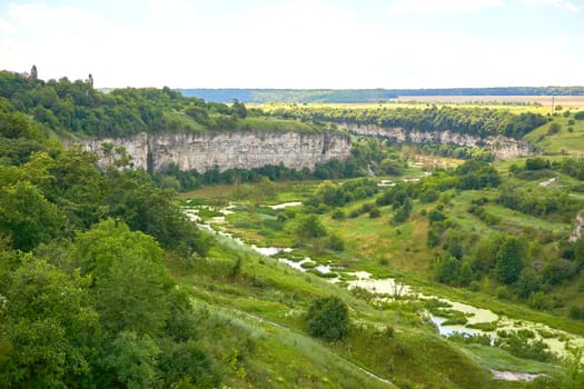 a deep gorge, typically one with a river flowing through it