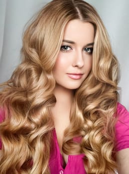 Beautiful blonde woman with curly volume hairstyle, long luxurious hair and beauty makeup, glamorous look face portrait for luxury fashion and natural cosmetics idea