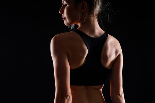 Fit sportswoman in leggings and sports bra looking away and while standing on a yellow red