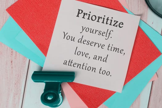 Motivational quote on colorful adhesive paper - Prioritize yourself. You deserve time, love, attention too.