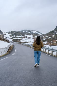 woman on a snowy road, a diverse couple at the Lyse road covered with snow to Krejag Norway Lysebotn, a road covered with snow in Spring