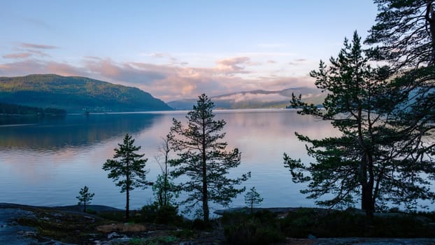 Byglandsfjord Lake with trees in Norway is, a beautiful mountain lake at sunrise