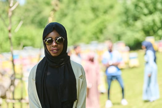 African American Muslim woman in hijab explores natural bee farms for honey production, blending tradition with sustainability in the serene countryside.