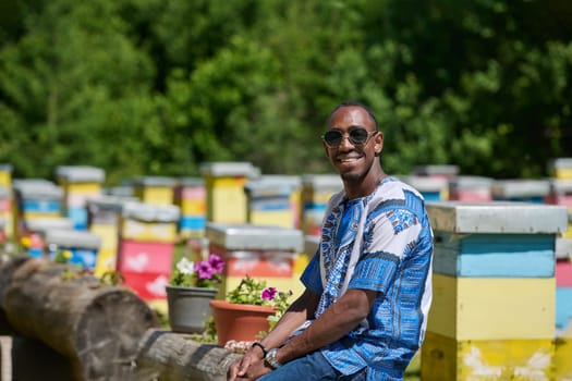 African American teenager clad in traditional Sudanese attire explores small beekeeping businesses amidst the beauty of nature