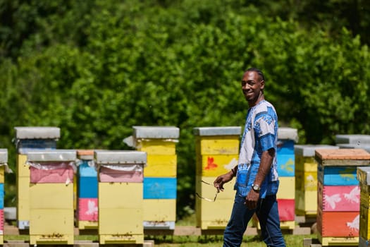 African American teenager clad in traditional Sudanese attire explores small beekeeping businesses amidst the beauty of nature