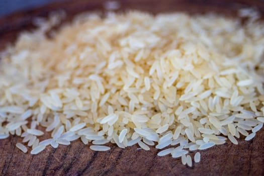Pile of rice grains close up. Dark background. Space for text. Healthy food.