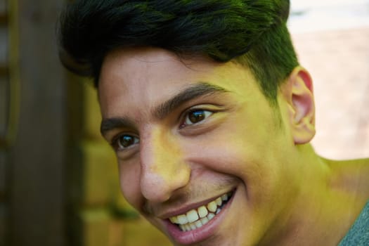 A closeup of a Middle Eastern man with a broad smile and beautiful white teeth, radiating warmth and joy.