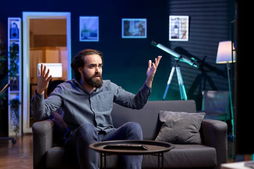 Sad supporter watching in disbelief own team getting defeated during live match broadcast. Mad man sitting on couch heartbroken by favorite club committing blunder and failing to win