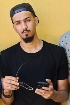 A striking close-up shot capturing the radiant smile of a Sudanese teenager, complemented by a chin and stylish cap using smartphone