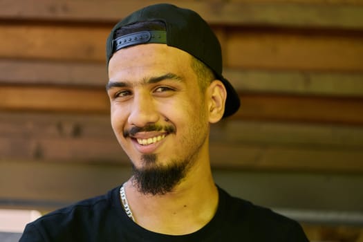 A striking close-up shot capturing the radiant smile of a Sudanese teenager, complemented by a chin and stylish cap.