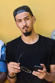 A striking close-up shot capturing the radiant smile of a Sudanese teenager, complemented by a chin and stylish cap using smartphone