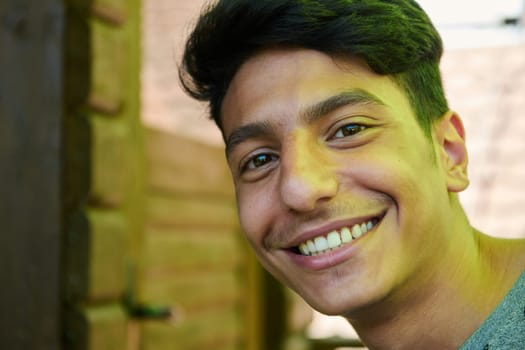 A closeup of a Middle Eastern man with a broad smile and beautiful white teeth, radiating warmth and joy.