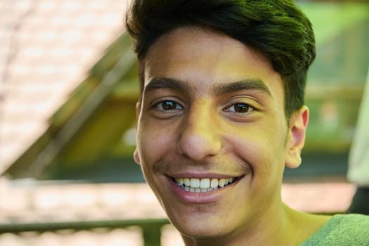 A closeup of a Middle Eastern man with a broad smile and beautiful white teeth, radiating warmth and joy.