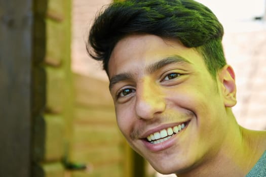 A closeup of a Middle Eastern man with a broad smile and beautiful white teeth, radiating warmth and joy.