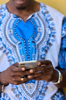 African American teenager adorned in traditional Sudanese clothing, seamlessly navigating the digital world with a smartphone in hand.