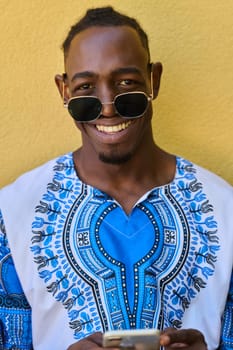 African American teenager adorned in traditional Sudanese clothing, seamlessly navigating the digital world with a smartphone in hand.