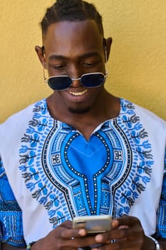 African American teenager adorned in traditional Sudanese clothing, seamlessly navigating the digital world with a smartphone in hand.