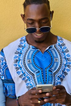 African American teenager adorned in traditional Sudanese clothing, seamlessly navigating the digital world with a smartphone in hand.