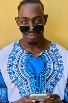 African American teenager adorned in traditional Sudanese clothing, seamlessly navigating the digital world with a smartphone in hand.