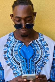 African American teenager adorned in traditional Sudanese clothing, seamlessly navigating the digital world with a smartphone in hand.