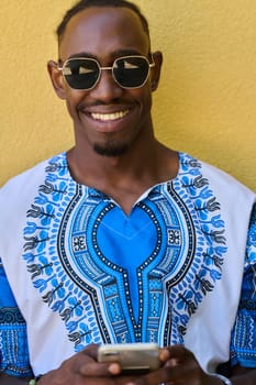 African American teenager adorned in traditional Sudanese clothing, seamlessly navigating the digital world with a smartphone in hand.