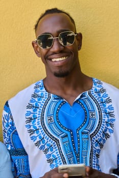 African American teenager adorned in traditional Sudanese clothing, seamlessly navigating the digital world with a smartphone in hand.