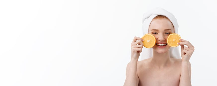 Great food for a healthy lifestyle. Beautiful young shirtless woman holding piece of orange standing against white background