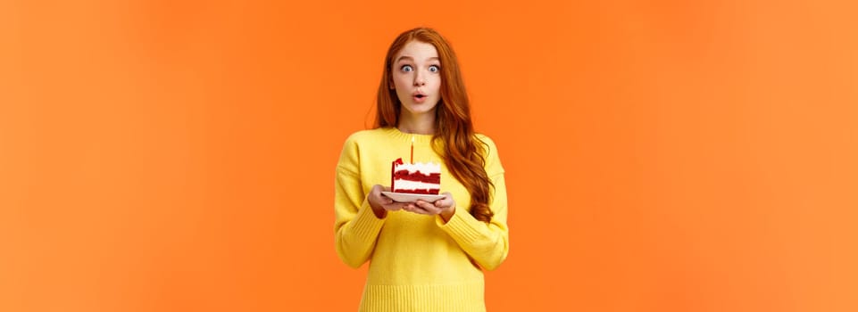 Carefree dreamy cute redhead girl making wish, quickly make-up desire to blow out candle on birthday cake, folding lips holding breath, want dream come true, look camera overwhelmed, b-day concept.