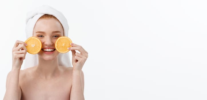 Great food for a healthy lifestyle. Beautiful young shirtless woman holding piece of orange standing against white background