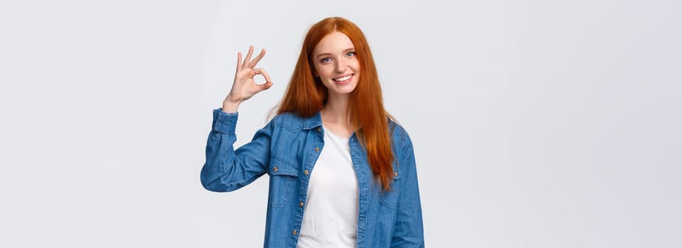 Teamwork, communication and people concept. Supportive good-looking female team member, girl coworker showing okay gesture and smiling with approval, agree or like something, white background.