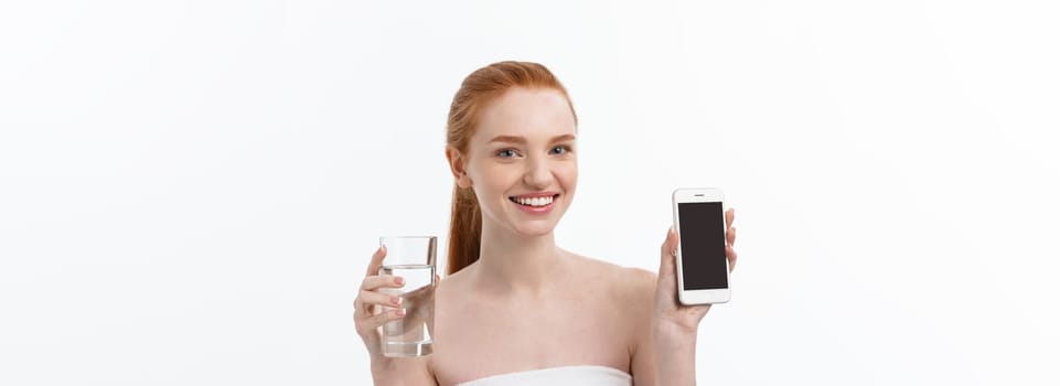 Happy smiling young woman with healthy skin reading and writing in mobile phone sms and drinking clean water. Consulting the diet. Closeup portrait.