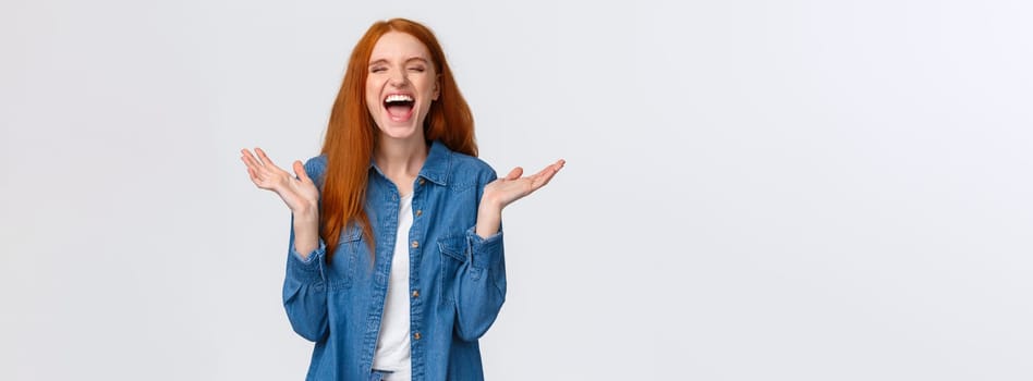 Lol so funny. Amused and carefree pretty redhead female student clap hands, applause with closed eyes as laughing out loud, having fun, hear hilarious joke, standing white background.